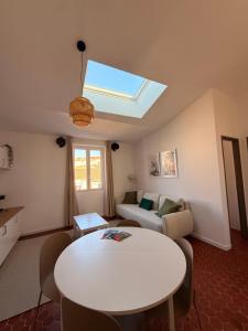 a living room with a white table and a skylight at Jolie T2 dans le centre ville Aubagne in Aubagne