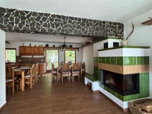 a living room with a fireplace and a dining room at Chata pri lese,Liptov in Bobrovec
