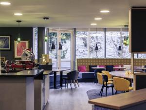 een restaurant met tafels, stoelen en een bank bij Mercure Stuttgart Zuffenhausen in Stuttgart