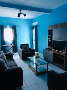 een blauwe woonkamer met een bank en een tafel bij Tranon'i Maria in Toamasina