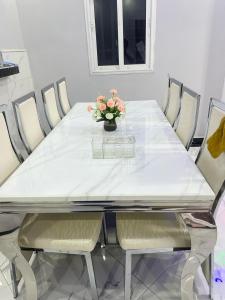 een eettafel met een vaas met bloemen erop bij Tranon'i Maria in Toamasina