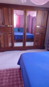 a bedroom with a blue bed and some wooden cabinets at Tranon'i Maria in Toamasina