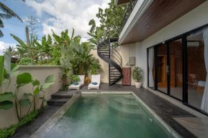 a pool in the backyard of a house with plants at Waringin Villa Ubud in Ubud