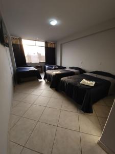 een hotelkamer met 3 bedden en een raam bij HOTEL Regency Plaza in Pisco
