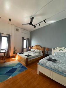 een slaapkamer met twee bedden en een plafondventilator bij Casa Primera in Luang Prabang