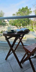een houten tafel met een open boek op een balkon bij HOTEL Regency Plaza in Pisco