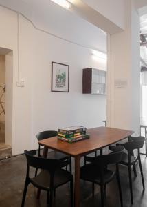een eettafel met stoelen en boeken erop bij Aayu Seckchuan - 3 mins walk to Love Lane in George Town