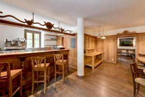 een keuken met houten kasten en een bar met stoelen bij Albergo Locanda Mezzosoldo in Mortaso