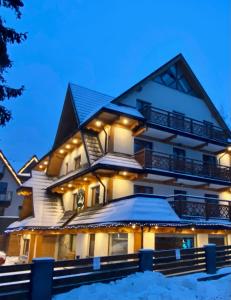 a house covered in snow at night at Villa Kaplowa Chata & SPA in Zakopane