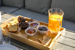 een schaal met muffins en een glas sinaasappelsap bij San Francisco maisonette in Rhodos-stad