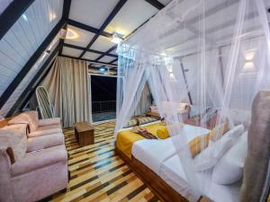 a bedroom with a canopy bed and a couch at White Moon Cabin & Cottage in Ella