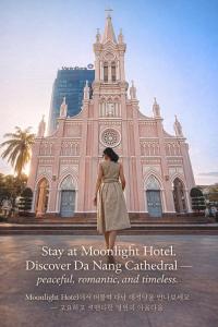 een vrouw die voor een kerk staat bij Moonlight Hotel & Apartment in Da Nang