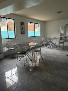 una sala da pranzo con sedie, tavoli e finestre di Hotel Capri a Iquique