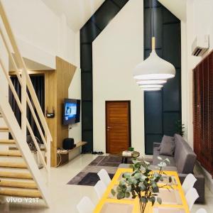 een woonkamer met een bank en een tafel bij THE HOLM At Khaoyai in Pak Chong