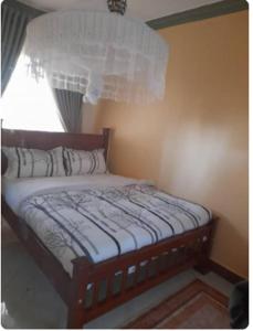 een klein bed in een kamer met een raam bij Icon Hotel in Kampala