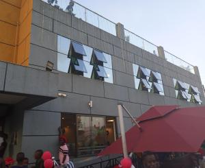 een groep mensen die buiten een gebouw staan bij Icon Hotel in Kampala