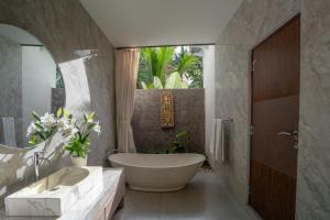 a bathroom with a large tub and a sink at Waringin Villa Ubud in Ubud +18 photos