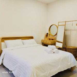 een slaapkamer met een bed met twee handdoeken erop bij THE HOLM At Khaoyai in Pak Chong