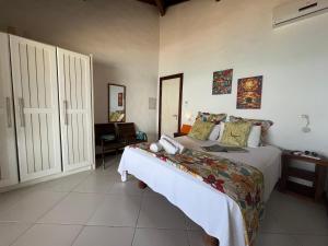 a bedroom with a bed and a chair in it at Casa Varandão, 1ª praia, Morro de São Paulo in Cairu +33 photos