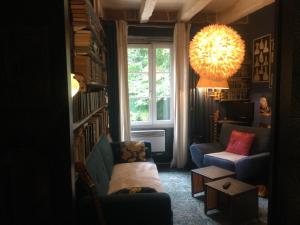 een woonkamer met een bank en een raam bij Piscine,jacuzzi,LUXE ,,clim,WiFi ,Collonges la rouge,moulin historique in Collonges