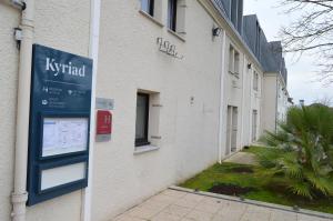 een bord aan de zijkant van een gebouw bij Kyriad Argenteuil in Argenteuil