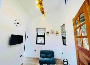 a living room with a blue chair and a tv at Staycation with Swimming Pool Lipa Batangas in Palavit
