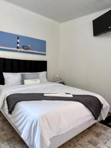 a bedroom with a large white bed with a lighthouse at 'LK Accommodation in WALVIS Bay- close Independence Beach in Walvis Bay