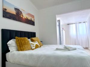 a bedroom with a large white bed with yellow pillows at 'LK Accommodation in WALVIS Bay- close Independence Beach in Walvis Bay