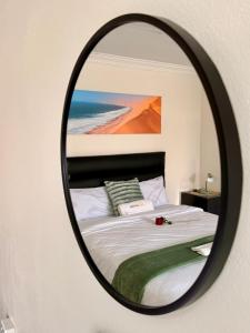 a bedroom with a bed with a mirror on the wall at 'LK Accommodation in WALVIS Bay- close Independence Beach in Walvis Bay