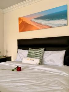 a white bed with a flower on top of it at 'LK Accommodation in WALVIS Bay- close Independence Beach in Walvis Bay