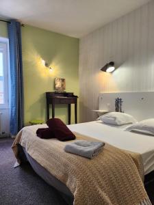 een slaapkamer met twee bedden en een tafel erin bij Ariane Hôtel in Vichy