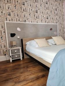 a bedroom with a bed and a wall of books at Ariane Hôtel in Vichy