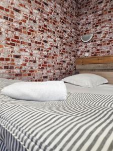 a bed in a room with a brick wall at Ariane Hôtel in Vichy