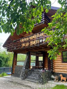 un edificio in legno con un cartello sopra di Căsuța Bunicilor de la Munte a Ceahlău