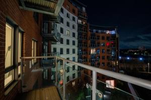 a balcony of a apartment building at night at Stylish 2 Bedroom APT with Balcony in Leeds