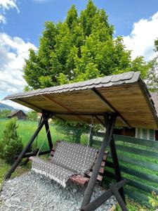 un'altalena con un tetto sopra. di Căsuța Bunicilor de la Munte a Ceahlău