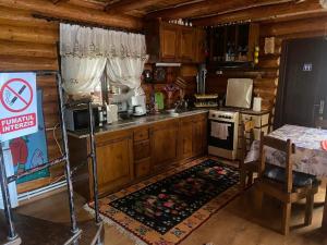 a kitchen with wooden cabinets and a stove top oven at Căsuța Bunicilor de la Munte in Ceahlău