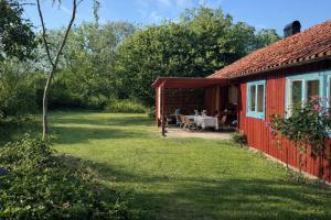 una casetta rossa con un tavolo nel cortile di Djupvik - Oland's sunny coast a Borgholm
