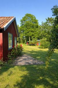 una casa rossa con un cortile accanto a una casa di Djupvik - Oland's sunny coast a Borgholm