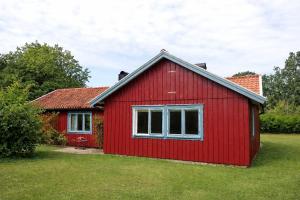 una casa rossa con una finestra in un cortile di Djupvik - Oland's sunny coast a Borgholm Altre 11 foto