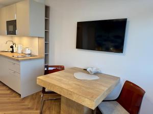 ein Esstisch mit Stühlen und eine Küche in der Unterkunft Boje in Westerland