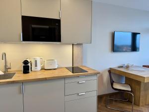 eine Küche mit weißen Schränken und einer Arbeitsplatte in der Unterkunft Boje in Westerland