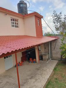 ein Haus mit rotem Dach und Garage in der Unterkunft Casa Tlatlauqui in Xotiocuautitla