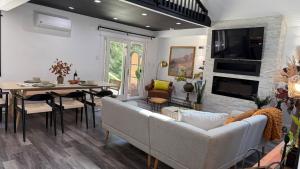 een woonkamer met een bank en een eetkamer bij Creekside Family Dreamland - Play, Firepit, Arcade in Pocono Summit