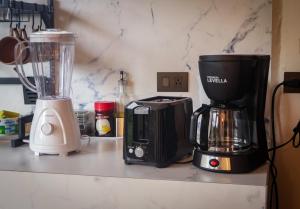 a kitchen counter with a blender and a coffee maker at Divan Jungle Lodge in Fortuna