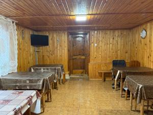 een kamer met tafels en stoelen en een tv bij Sadyba Zavitaiko in Jaremtsje