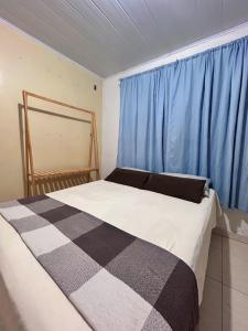 een slaapkamer met een groot bed met blauwe gordijnen bij Casa Pousada Norte da Ilha in Florianópolis