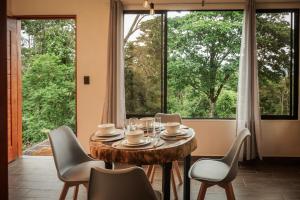 a dining room with a table and chairs and a large window at Divan Jungle Lodge in Fortuna