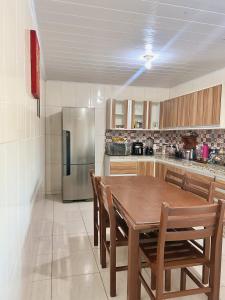 een keuken met een houten tafel en een roestvrijstalen koelkast bij Casa Pousada Norte da Ilha in Florianópolis