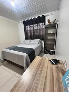 een slaapkamer met een bed en een houten vloer bij Casa Pousada Norte da Ilha in Florianópolis